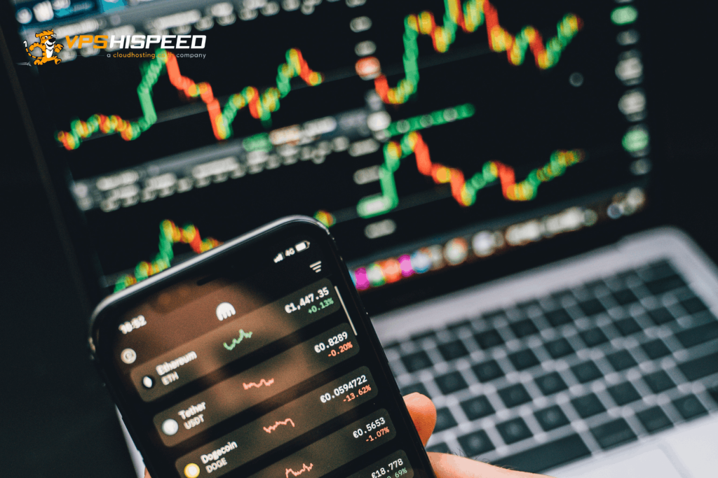 Smartphone displaying cryptocurrency prices with forex trading charts on a laptop screen in the background